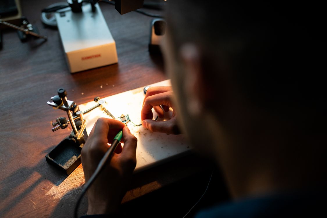 Engineer soldering electronic components in a clean assembly workshop