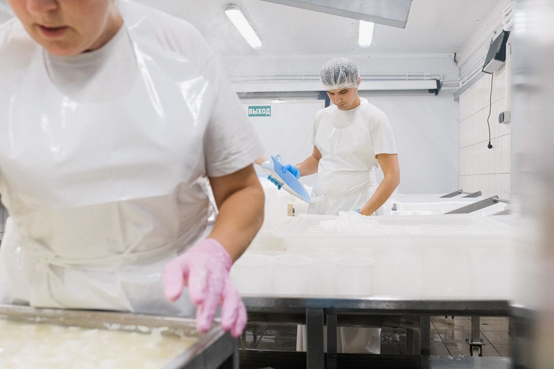Food packaging and manufacturing floor with workers processing goods