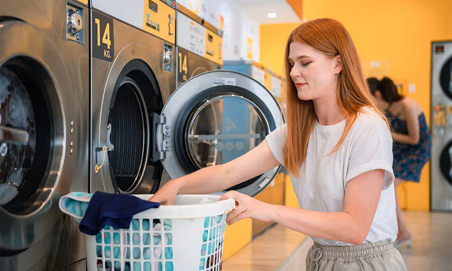 Customer using laundromat washing machines