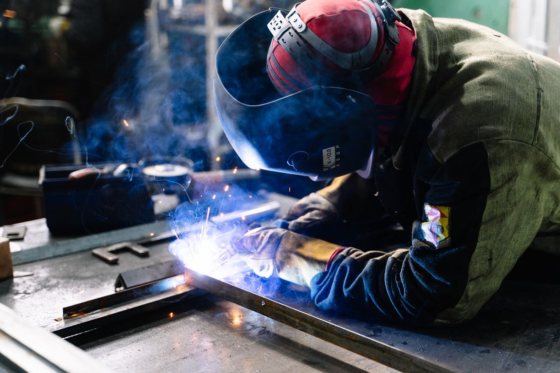 Welder working with sparks in a metal fabrication shop