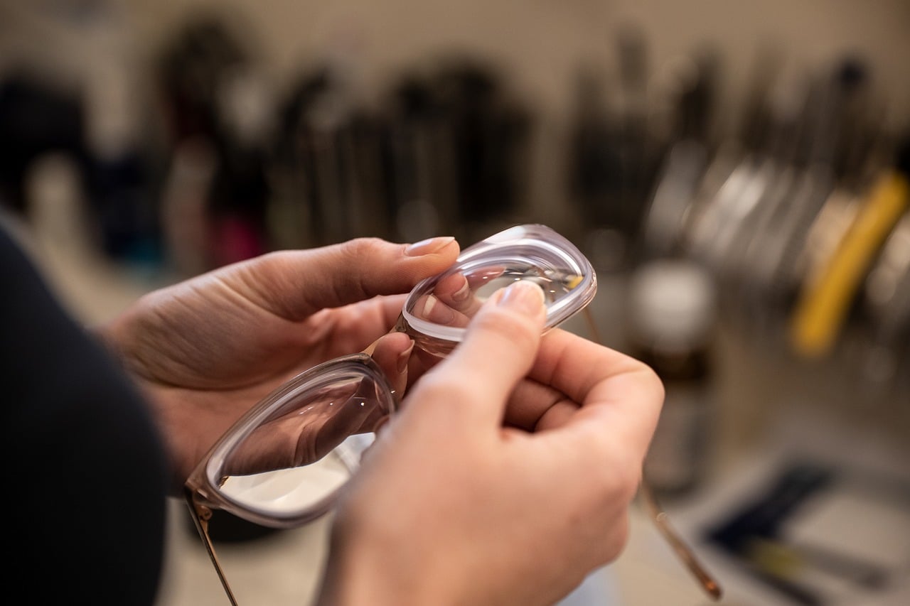 Optician fitting eyeglass lenses in an optical retail showroom