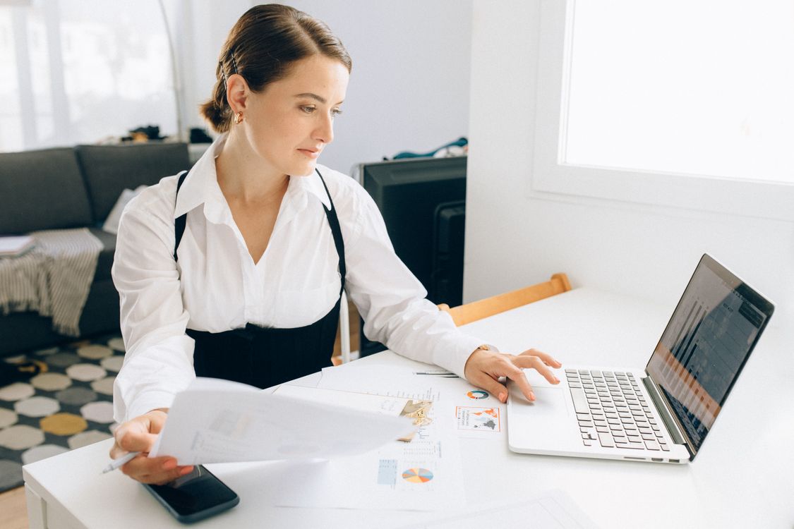 Print shop owner reviewing order and insurance paperwork at a desk