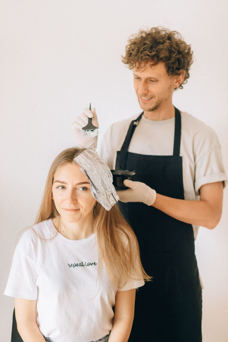 Hairdresser applying color to a client in a salon
